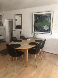 Guesthouse Trabjerg في فيجلي: طاولة طعام مع كراسي و لوحة على الحائط