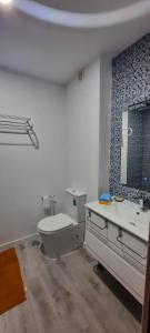 a bathroom with a toilet and a sink and a mirror at Casa Das Conchas in Costa da Caparica +31 photos