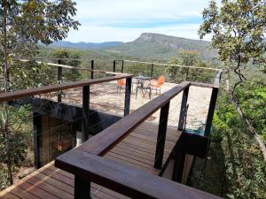 eine Holzterrasse mit einem Tisch und Stühlen darauf in der Unterkunft Casa da Serra in Cavalcante