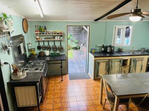 a kitchen with a stove and a table in it at La Kaz LANGEVIN in Saint-Joseph
