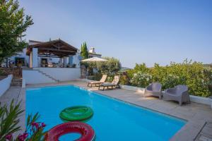 a swimming pool with two chairs and a house at Casa do Chapim-azul in Marvão