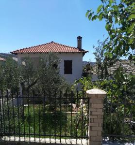 une clôture en fer noir avec une maison en arrière-plan dans l'établissement ΔΙΑΚΟΠΕΣ ΣΤΗ ΘΑΣΟ ! ! !, à Theológos
