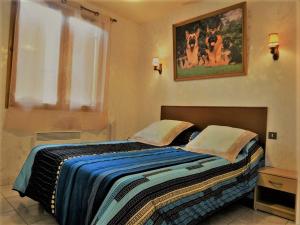 a bedroom with a bed with a blue blanket and a window at Gite les Acacias - les gites des hauts de vialot in Auriac-du-Périgord +7 photos