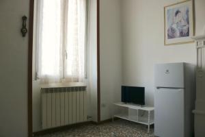 a room with a refrigerator and a window with a television at Le Residenze Della Poetessa in Corsico