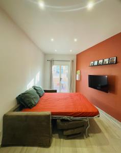 une chambre avec un lit avec un mur rouge dans l'établissement Notre cocon sudiste, à Cogolin