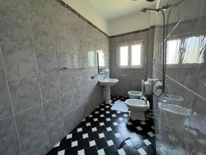 y baño con 2 aseos, lavamanos y ducha. en Green Garden Villa en Durrës