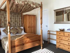 a bedroom with a wooden canopy bed and a dresser at Belmont Hotel in Blackpool +110 photos
