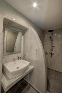a bathroom with a sink and a mirror at Remvi Suites in Firostefani