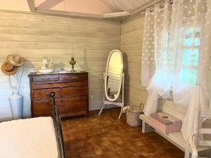a bathroom with a dresser and a mirror at La Kaz LANGEVIN in Saint-Joseph