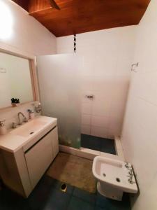 a white bathroom with a sink and a toilet at Casa Ideal para Turistas en Mendoza, Autocheckin, Céntrica, Patio con Parrilla y Parking privado Gratis a 100 mts in Mendoza