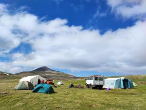a group of tents and a truck in a field at Highland Hostel in Yerevan