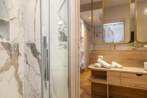 a bathroom with a shower and a television at Salus Smart & Chic Hotel in Lido di Jesolo