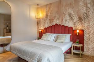 una camera con un grande letto con testiera rossa di Salus Smart & Chic Hotel a Lido di Jesolo