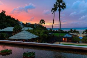 a sunset over a resort with palm trees and the ocean at Phuket Marriott Resort and Spa, Nai Yang Beach in Nai Yang Beach