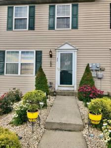 Uma casa com dois potes amarelos à frente. em 3 Bedroom Home with Treadmill & Large Fenced yard em Myerstown