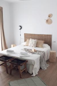 1 dormitorio con 1 cama blanca, mesa y sillas en Villa con solarium y ducha exterior, en Gelves