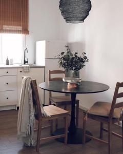 una cocina con mesa y sillas con una planta en Villa con solarium y ducha exterior, en Gelves