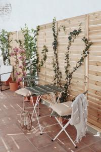 una mesa y sillas frente a una pared con plantas en Villa con solarium y ducha exterior, en Gelves