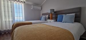 sypialnia z 2 łóżkami i oknem w obiekcie Sun's House w mieście Ericeira