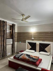 Dream Land Hotel في جامو: غرفة نوم بسرير ومروحة سقف