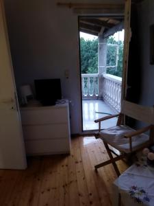 a living room with a door open to a balcony at House Near Airport Pallini Metro Station in Pallíni