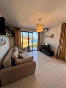 a living room with a couch and a television at Apartment with pool in Becici