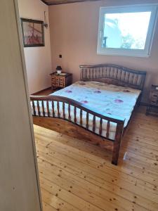 a bedroom with a large wooden bed with a window at House Near Airport Pallini Metro Station in Pallíni