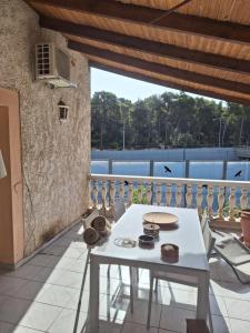 a room with a white table and a balcony at House Near Airport Pallini Metro Station in Pallíni