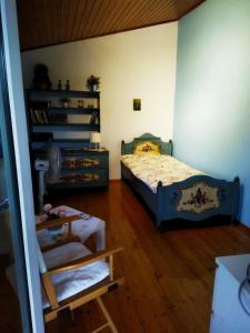 een slaapkamer met een bed en een boekenplank bij House Near Airport Pallini Metro Station in Pallíni