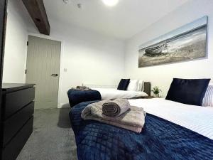 a bedroom with two beds with towels on the bed at 1 Silvester Square in Hull