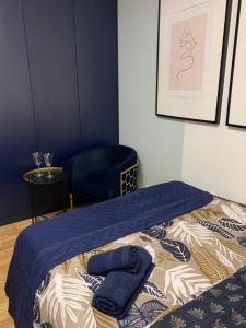een bed met twee blauwe handdoeken in een kamer bij Indygo Apartment in Krakau