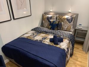 een bed met een blauw dekbed in een kamer bij Indygo Apartment in Krakau