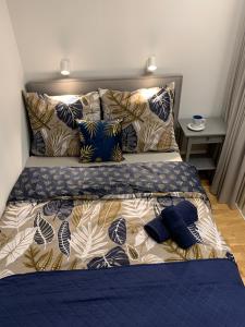 een bed met een blauw dekbed en kussens erop bij Indygo Apartment in Krakau