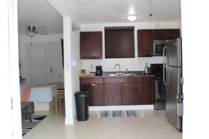 a kitchen with wooden cabinets and a stainless steel refrigerator at Stunning suite by hard rock stadium and casino in Miami +7 photos