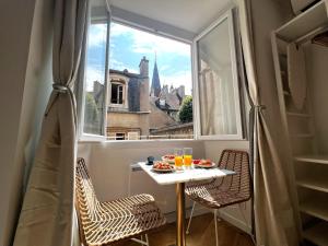 - une table et des chaises dans une chambre avec fenêtre dans l'établissement La Comtesse - Our Lady Church View - Heart of Dijon, à Dijon