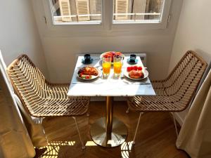 une table avec des assiettes de nourriture et deux verres de jus dans l'établissement La Comtesse - Our Lady Church View - Heart of Dijon, à Dijon