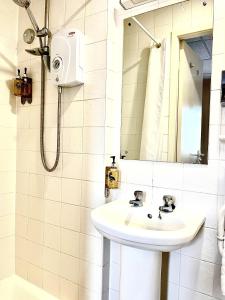 a white bathroom with a sink and a mirror at Clifton Court Hotel in Blackpool +59 photos