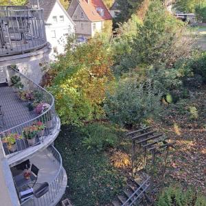 einen Blick über den Garten mit einer Bank und einem Balkon in der Unterkunft Kleiner Urwald in Remscheid