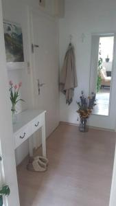 ein weißes Badezimmer mit einem Waschbecken und einem Spiegel in der Unterkunft Kleiner Urwald in Remscheid