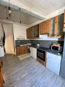 kuchnia z białymi urządzeniami i drewnianymi szafkami w obiekcie Maison de ville atypique w Orange