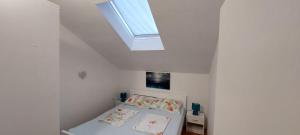 a white room with a bed and a skylight at Son de Mar Novalja-Pag Apartment in Novalja