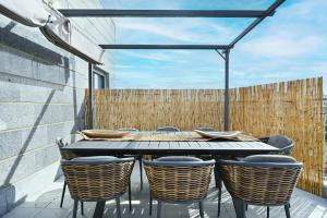 a table and chairs on a patio with a fence at The Radiant By HolyGuest in Tel Aviv