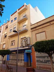 a building on a street with a bench in front of it at Appartamentos Benicarló 3 in Benicarló