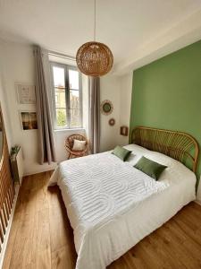 1 dormitorio con 1 cama grande y pared verde en Appartement Cosy Place Delille, en Clermont-Ferrand