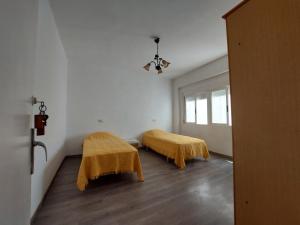 a room with two beds with yellow blankets at Appartamentos Benicarló 3 in Benicarló
