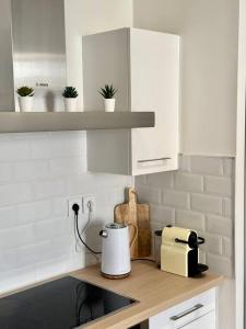 una cocina con armarios blancos y tostadora en una encimera en Appartement Cosy Place Delille, en Clermont-Ferrand