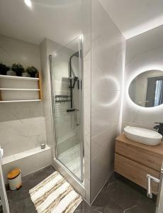y baño con ducha acristalada y lavamanos. en Appartement Cosy Place Delille, en Clermont-Ferrand