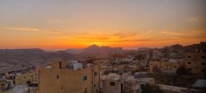 una vista de una ciudad con la puesta de sol en el fondo en Petra Sunset Bed & Breakfast, en Wadi Musa