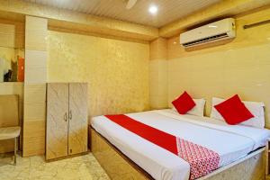 a bedroom with a bed with red pillows at Hotel Royal Inn in Kolkata