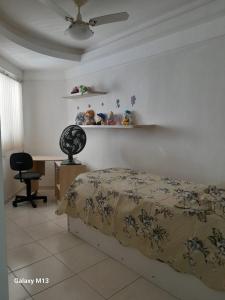 1 dormitorio con cama, silla y estanterías en Praia de Piedade, en Recife